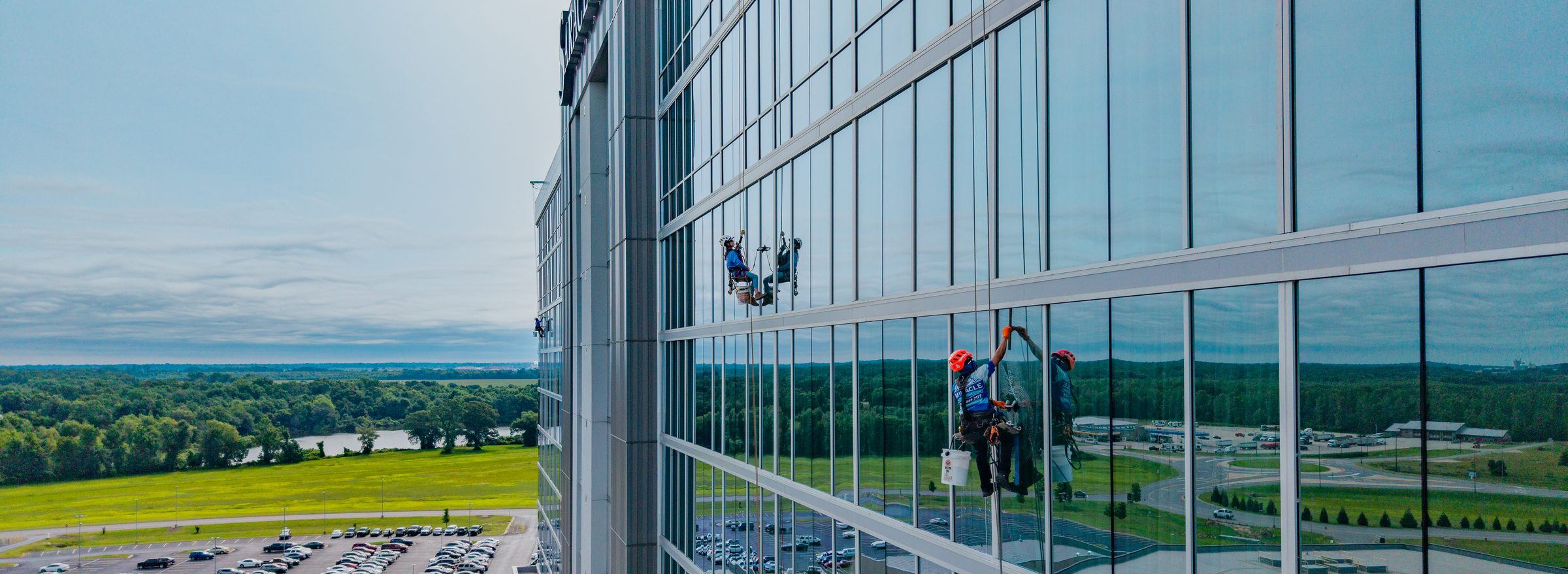 Miracle Window Cleaning technicians on rope access lines cleaning a high-rise glass facade in Central Arkansas