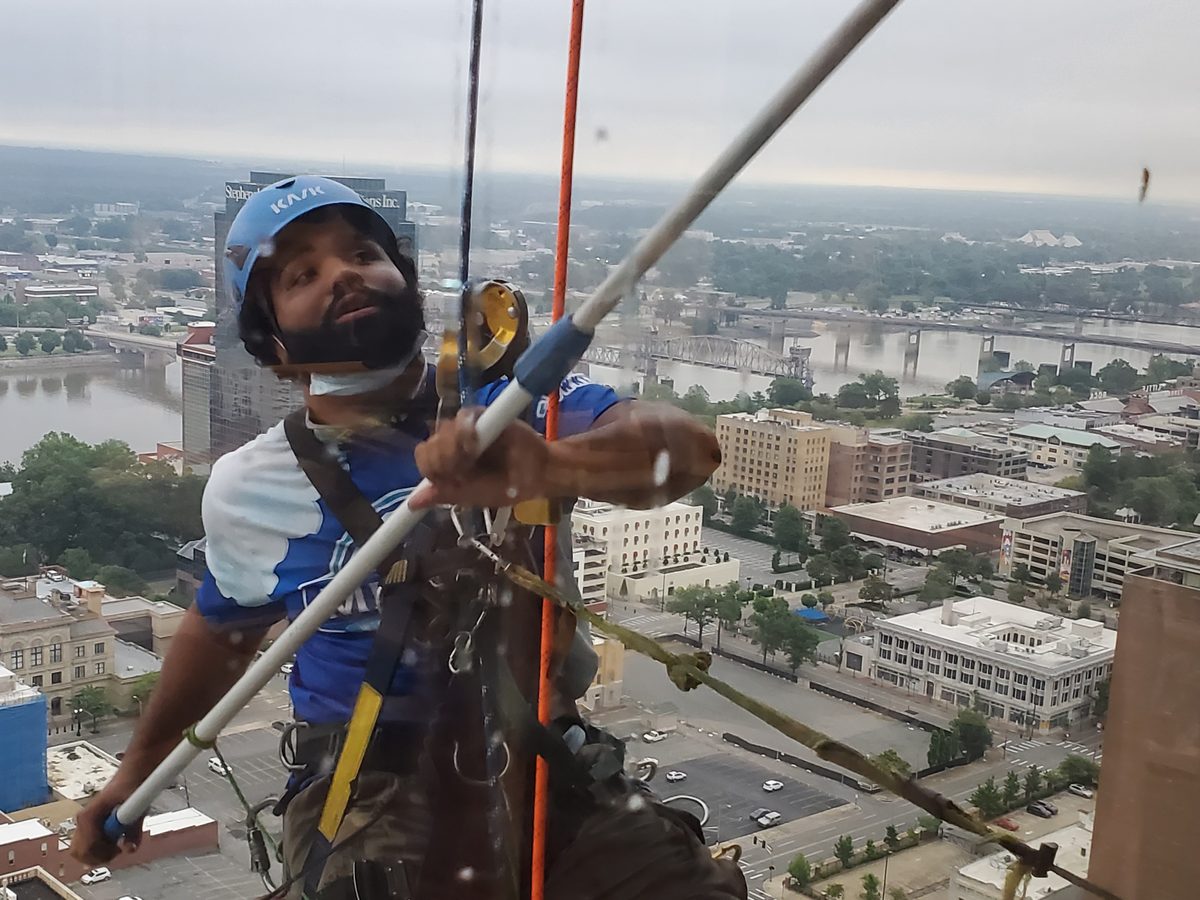 Miracle Window Cleaning technician on rope access lines high above downtown Little Rock Arkansas