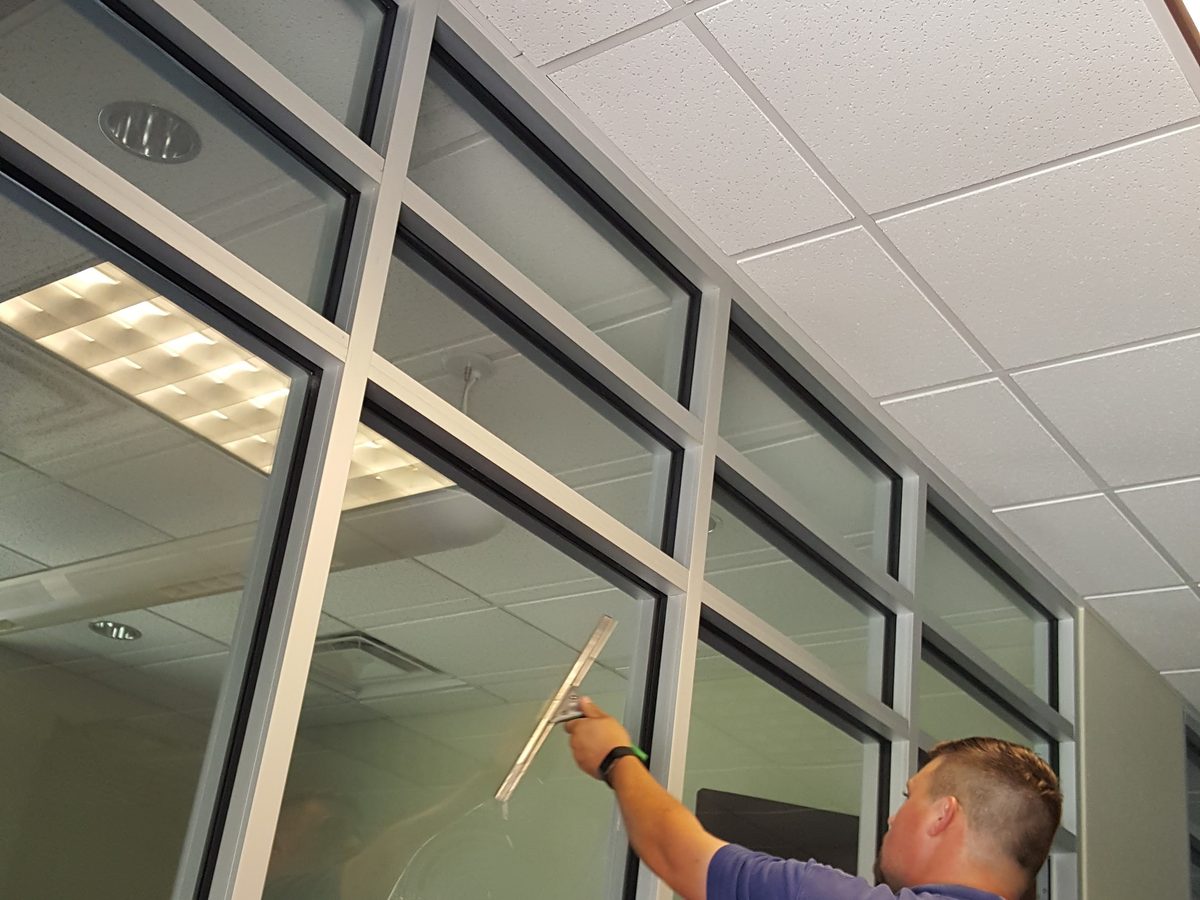 Miracle Window Cleaning technician drawing a squeegee down interior glass in Little Rock Arkansas